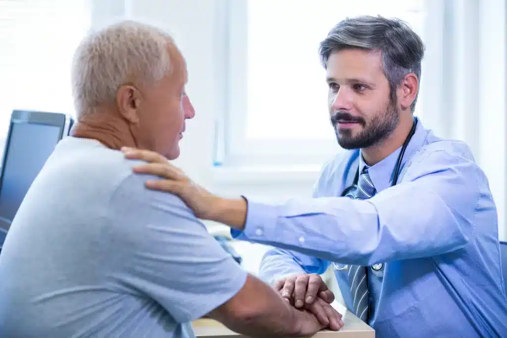 atencion-urologica-merida-con-enfoque-humano Médico brindando atención urológica en Mérida con cercanía y empatía, colocando la mano sobre el hombro del paciente durante la consulta.