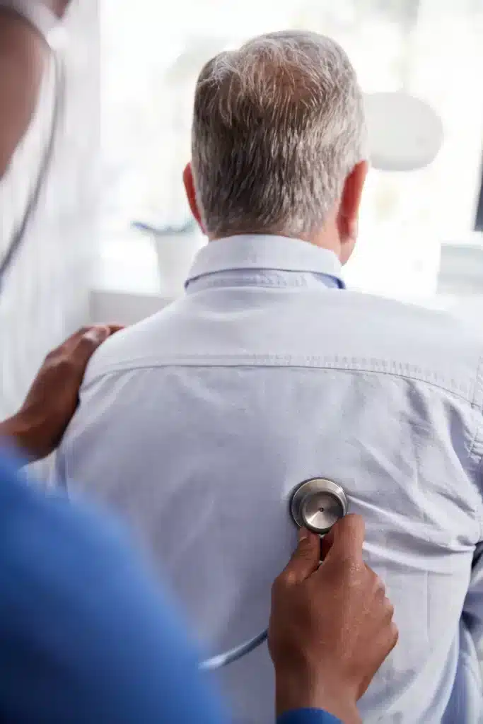consulta-presencial-urologia-merida-revision-completa Médico realizando auscultación a un paciente adulto mayor durante una consulta presencial de urología en Mérida, como parte de una revisión completa.