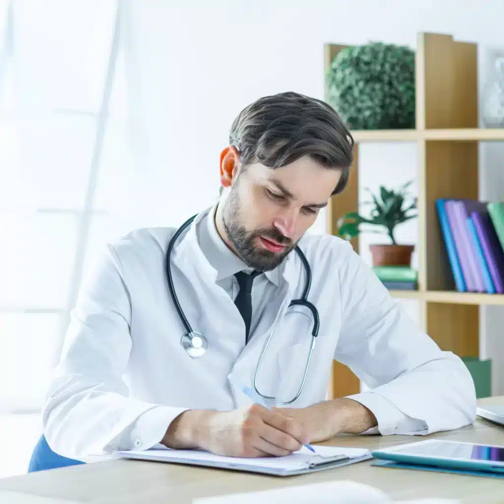 consulta-urologa-especializada-merida-preparacion-medica Médico escribiendo notas clínicas como parte de una consulta urológica especializada en Mérida, enfocada en precisión y diagnóstico.