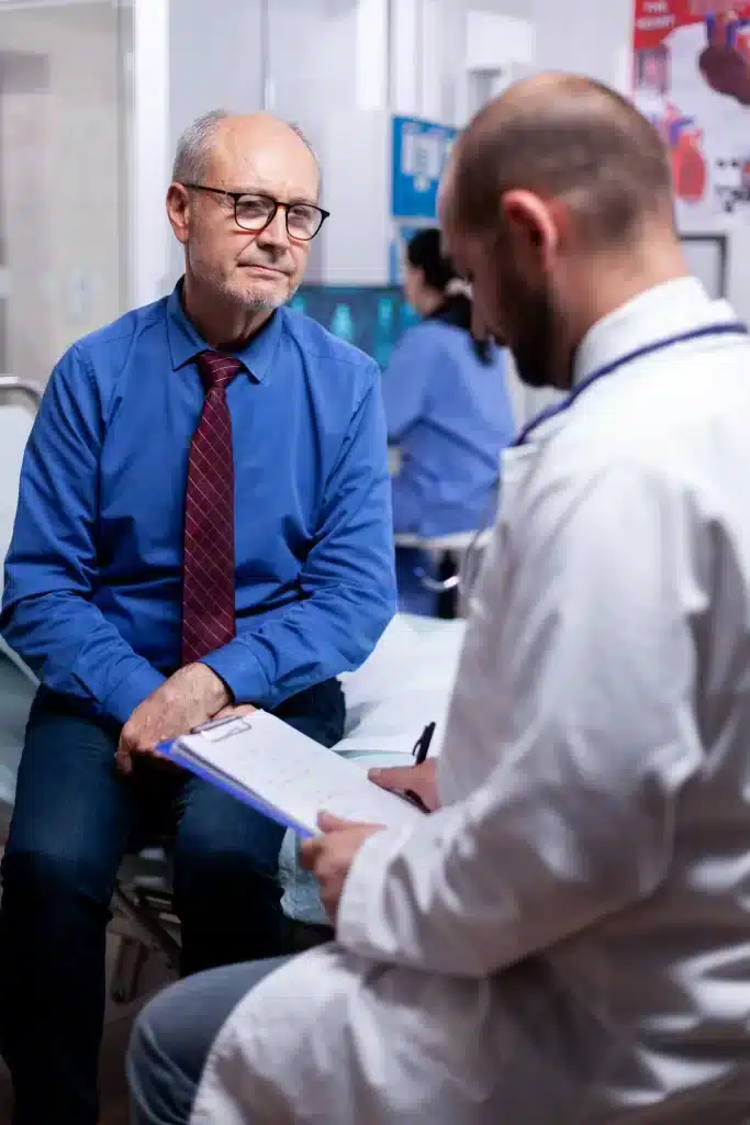 consulta-urologica-hombres-merida-evaluacion-personalizada Hombre mayor respondiendo preguntas médicas durante una consulta urológica para hombres en Mérida, con evaluación personalizada.