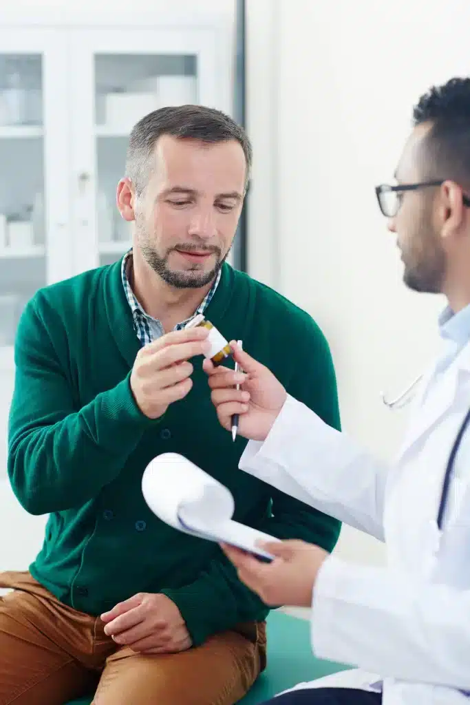 consulta-urologo-merida-entrega-de-tratamiento Urólogo en Mérida entregando indicaciones y medicamento a un paciente durante una consulta médica especializada.